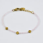 Gouden armband met roze kralen en gouden accenten