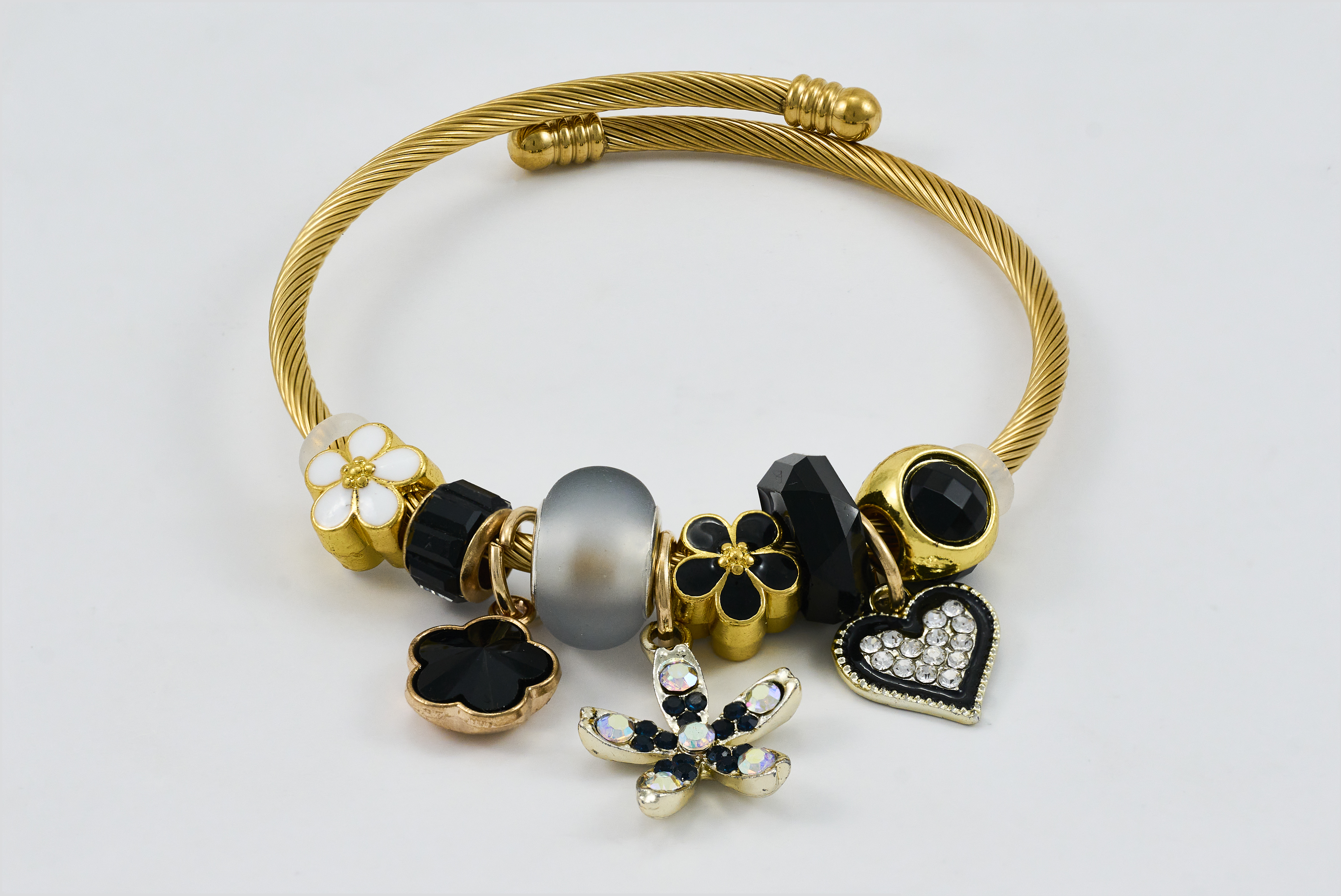 Gouden armband met zwarte en gouden bedels en luxe uitstraling