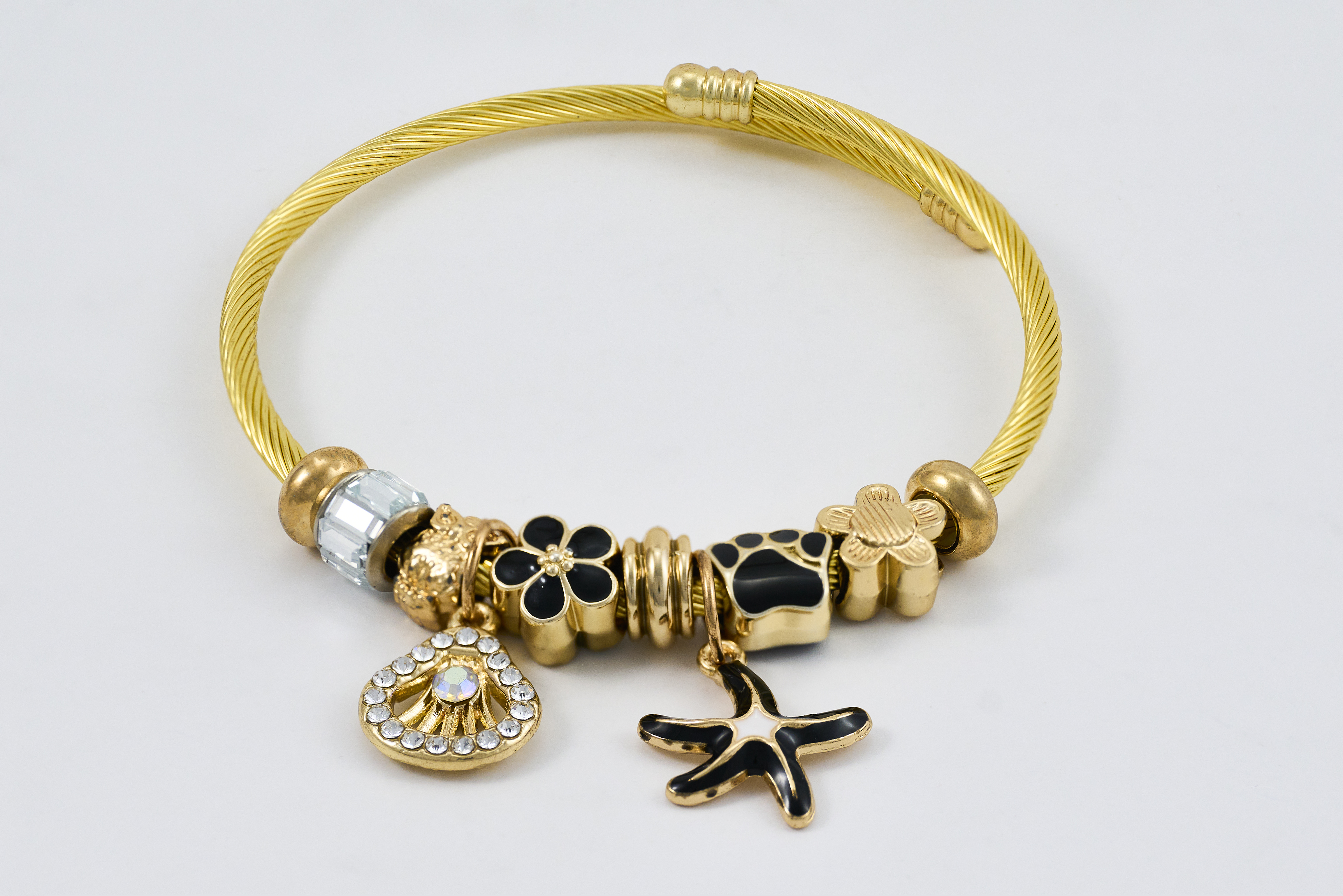 Gouden bangle met bedels en kristallen accenten