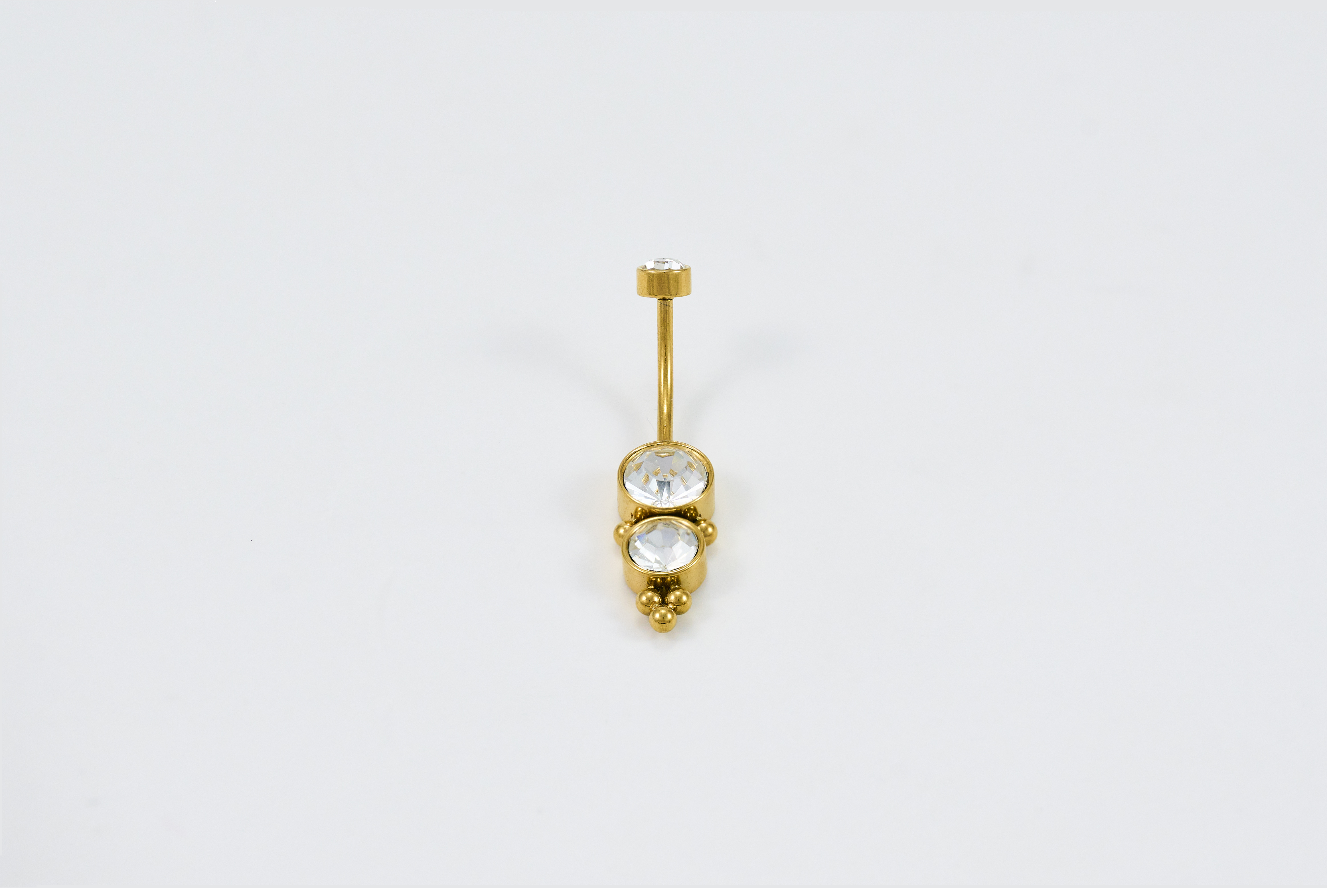 Gouden buikpiercing met schedeldesign