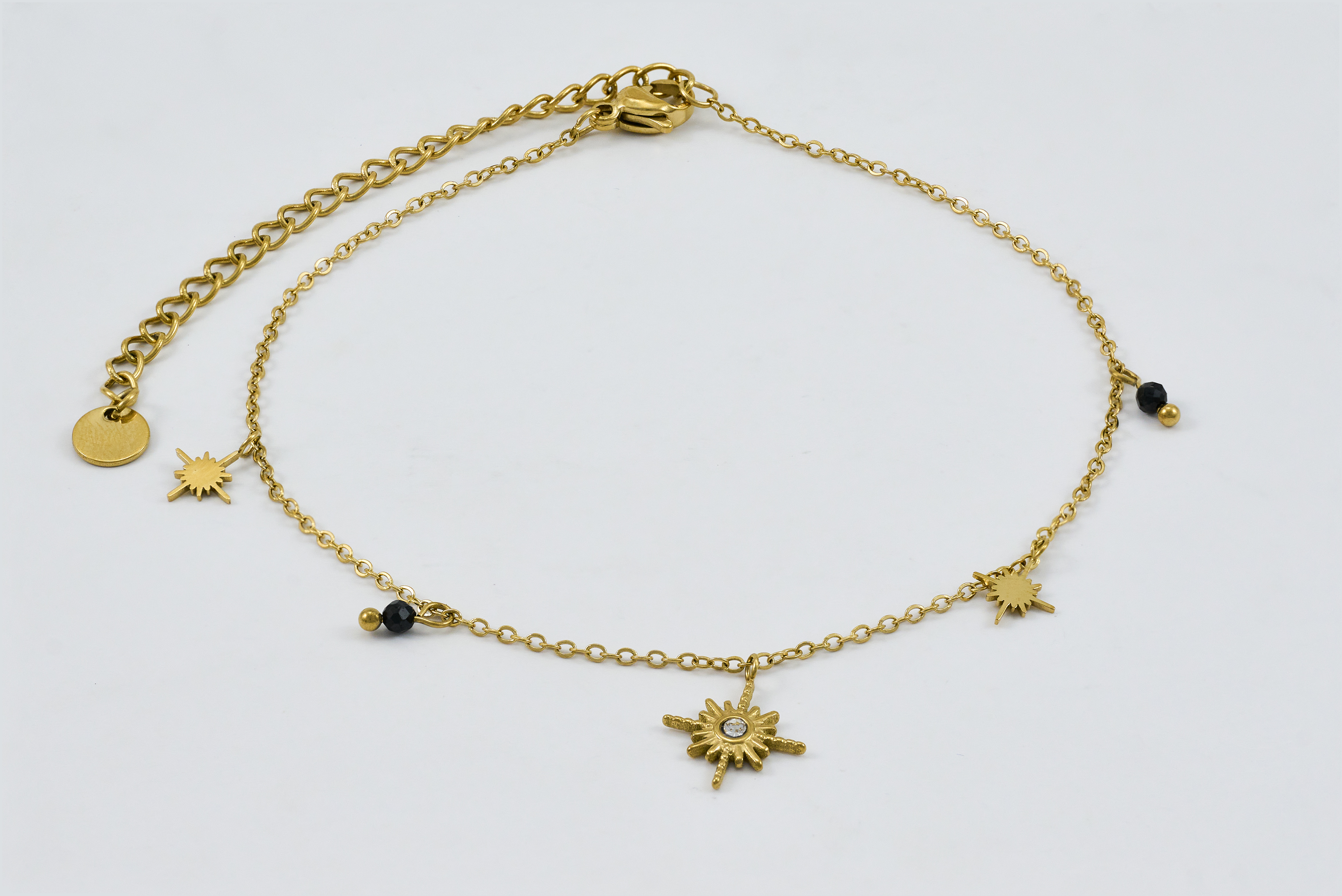 Gouden enkelband met zwarte steentjes