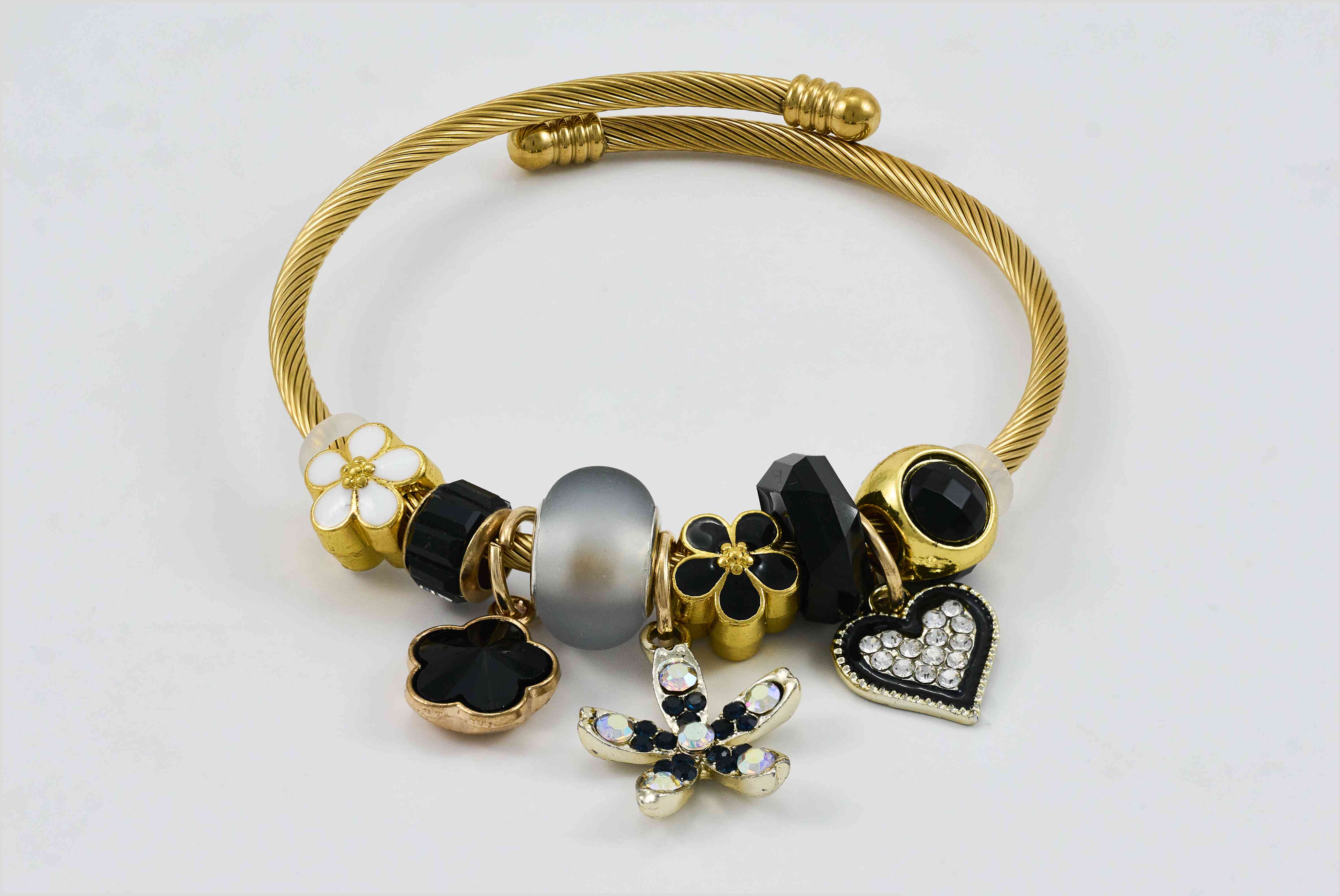 Gouden armband met zwarte en gouden bedels en luxe uitstraling