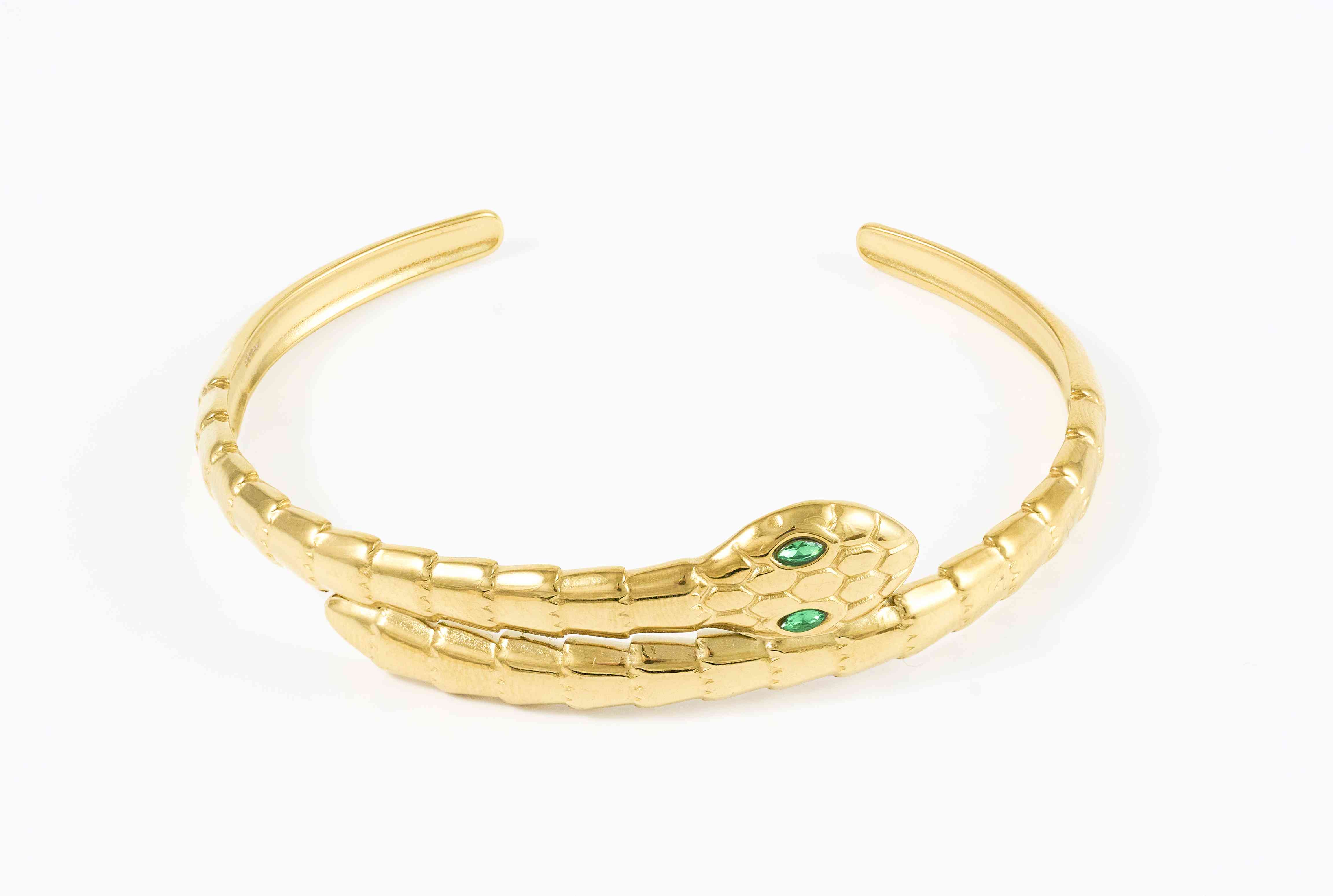 Gouden bangle met slangontwerp en groene steen detail
